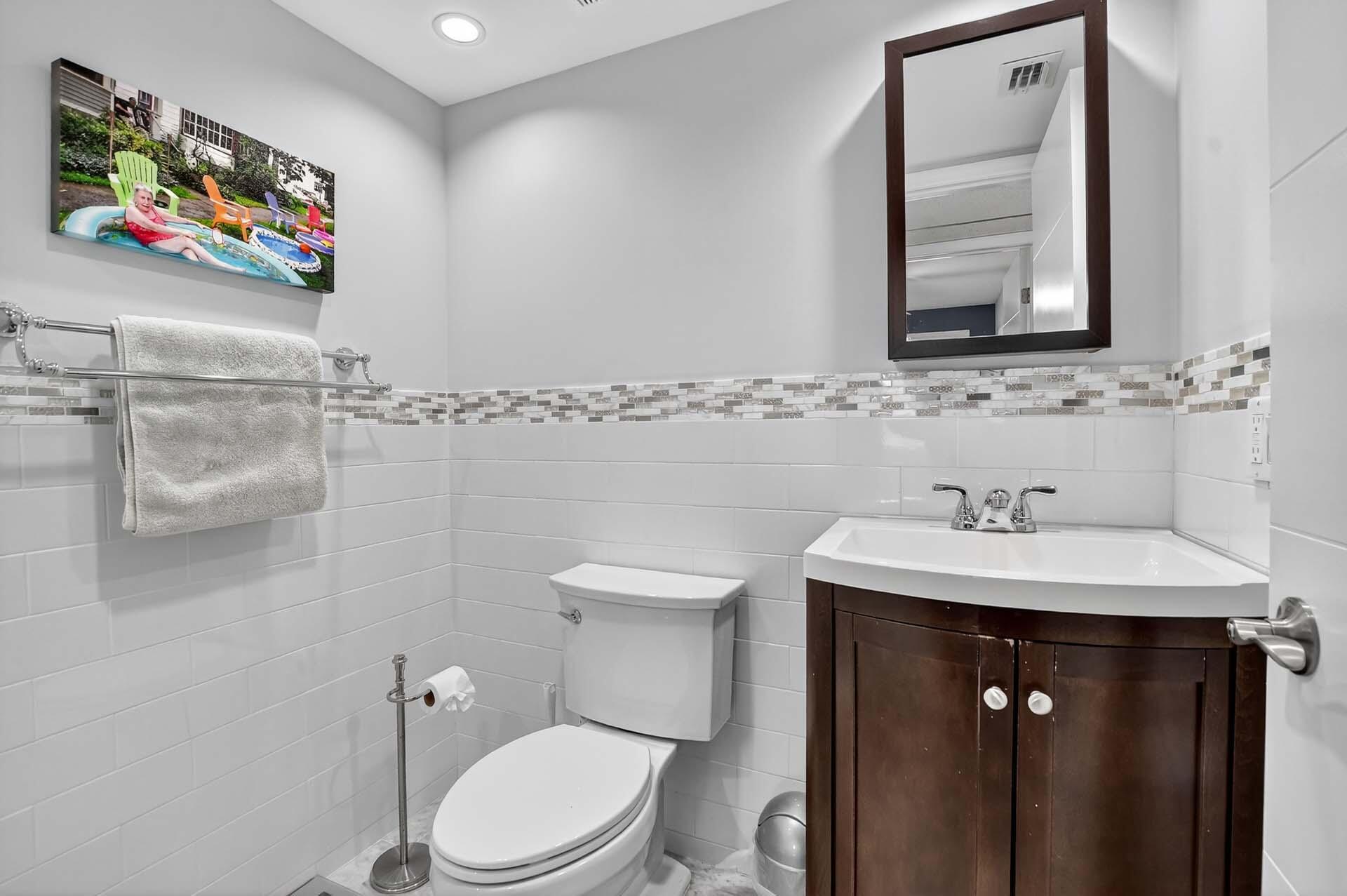 360 Flanders Drive, Unit H Delray Beach, FL 33484 - Photo 17 of 65 a bathroom with a toilet a sink and mirror