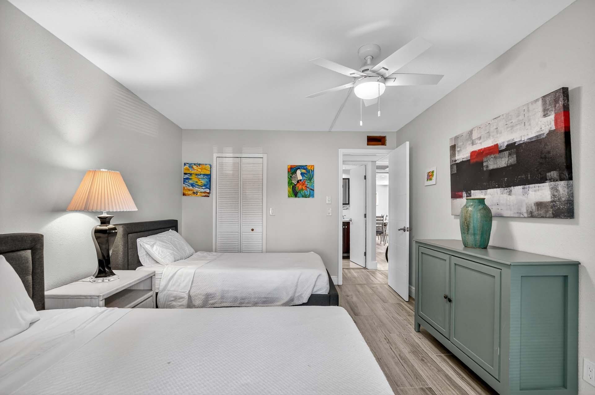 360 Flanders Drive, Unit H Delray Beach, FL 33484 - Photo 20 of 65 a bedroom with a bed and a chandelier