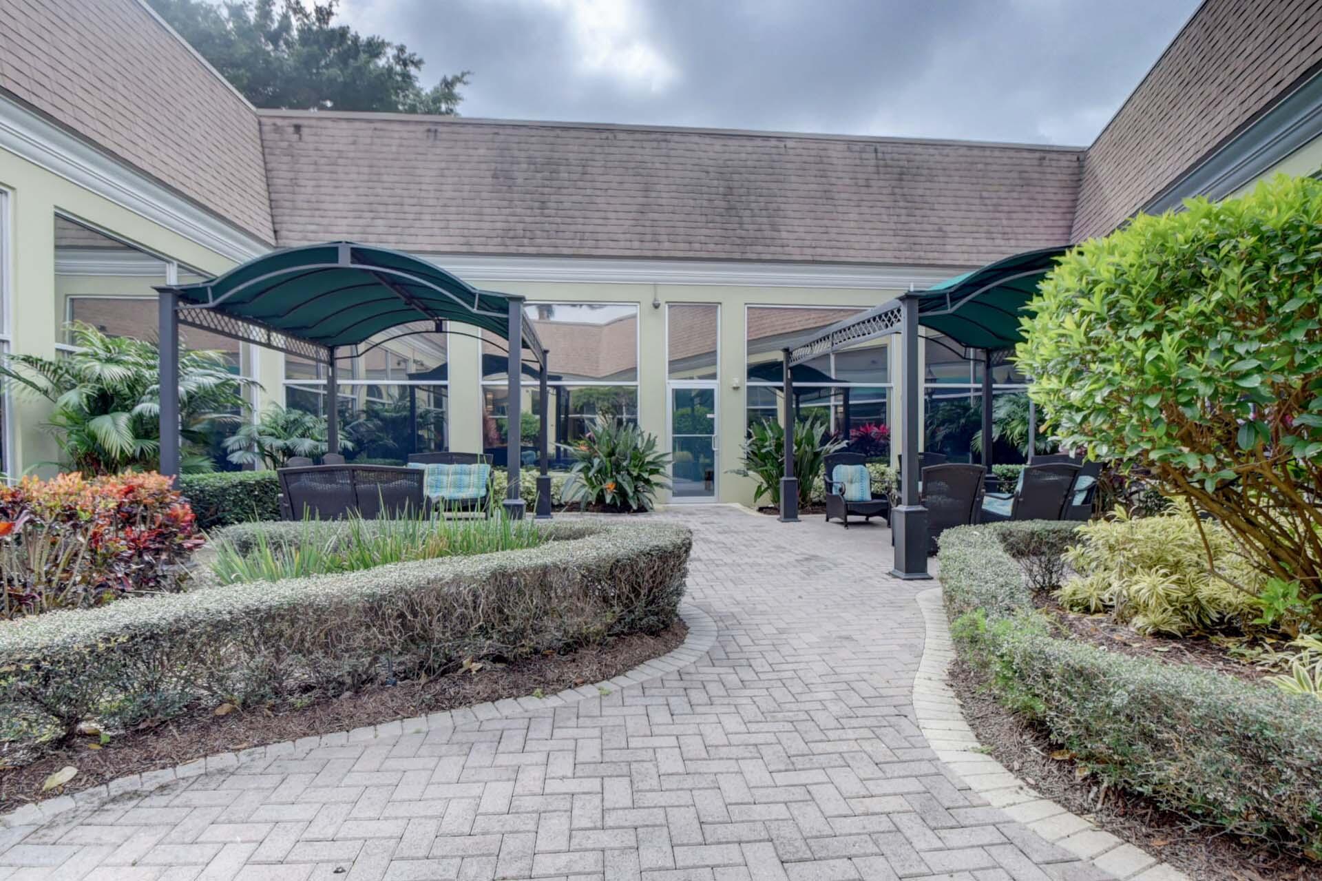 360 Flanders Drive, Unit H Delray Beach, FL 33484 - Photo 47 of 65 a view of a patio with table and chairs potted plants