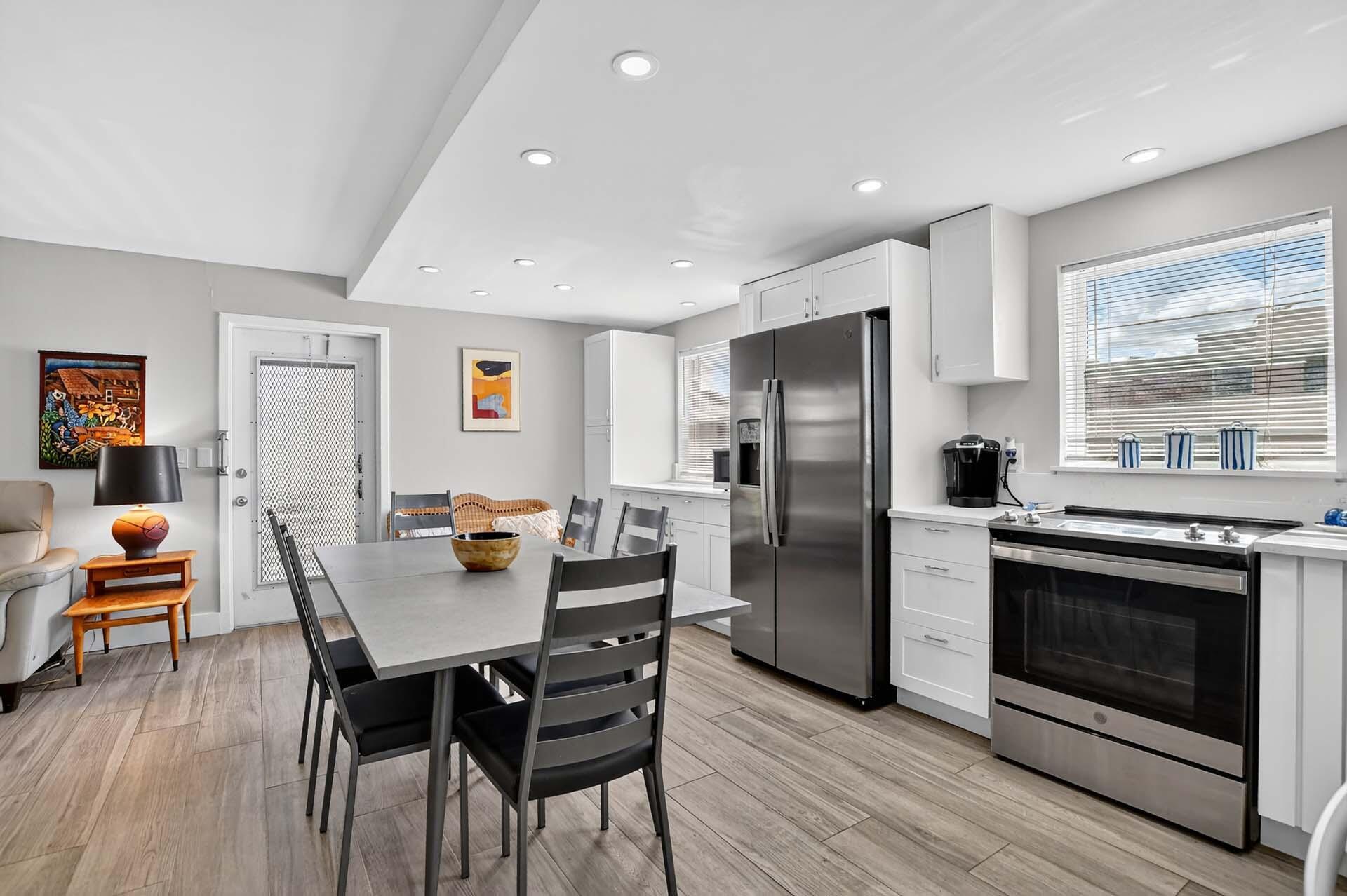 360 Flanders Drive, Unit H Delray Beach, FL 33484 - Photo 8 of 65 a kitchen with stainless steel appliances granite countertop a stove a refrigerator a dining table and chairs