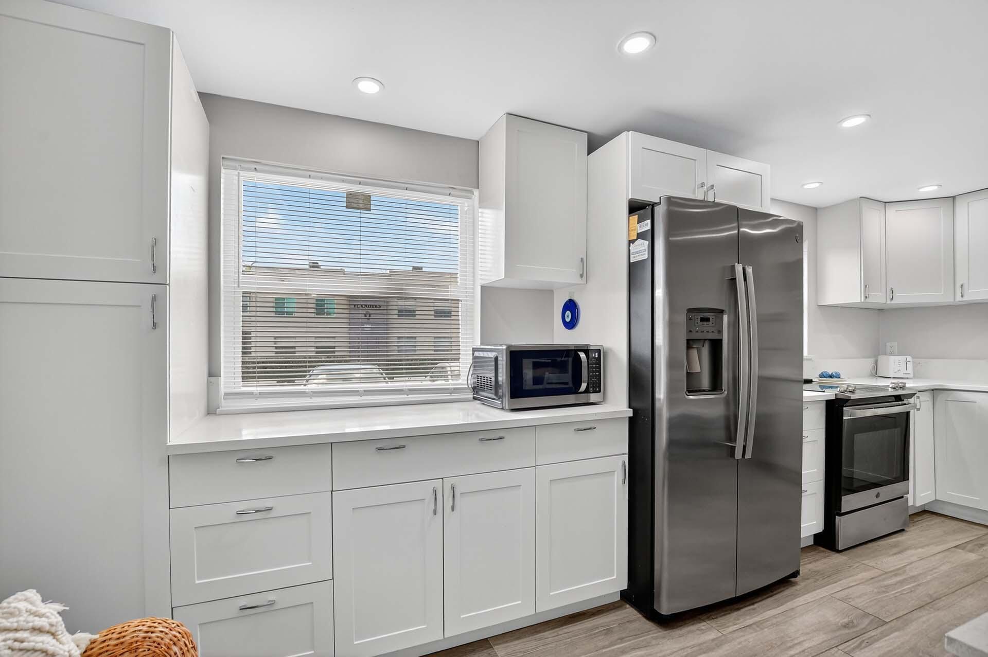 360 Flanders Drive, Unit H Delray Beach, FL 33484 - Photo 10 of 65 a kitchen with stainless steel appliances a refrigerator sink and stove