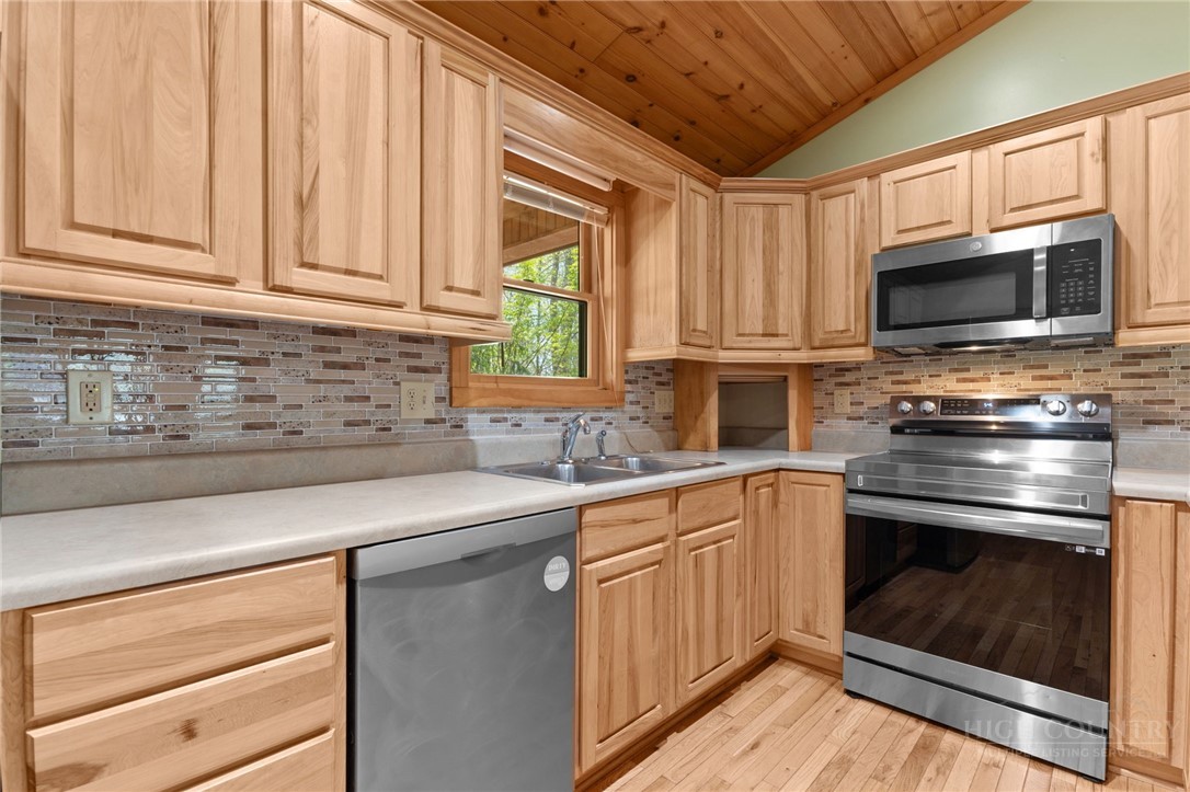 148 Woodby Ridge Road Vilas, NC 28692 - Photo 8 of 33 a kitchen with stainless steel appliances granite countertop a sink a stove a microwave and wooden cabinets