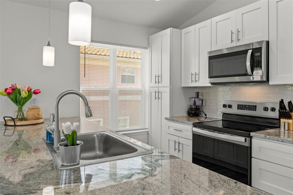10234 West Middleburg Loop, Unit 152 Homosassa, FL 34448 - Photo 11 of 28 a kitchen with a stove a microwave and cabinets