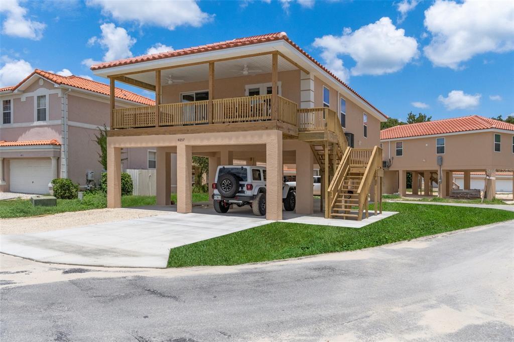 10234 West Middleburg Loop, Unit 152 Homosassa, FL 34448 - Photo 3 of 28 a view of a white house with a small yard and large trees