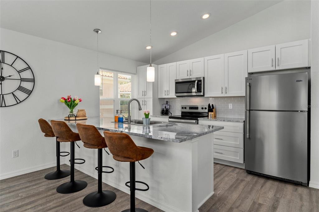 10234 West Middleburg Loop, Unit 152 Homosassa, FL 34448 - Photo 8 of 28 a kitchen with stainless steel appliances granite countertop a refrigerator a stove a sink a dining table and chairs with wooden floor