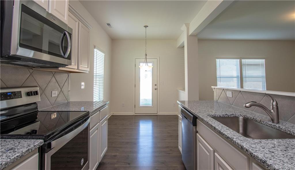 12532 Gotland Road, Unit 331 Midland, NC 28107 - Photo 14 of 26 a kitchen with stainless steel appliances granite countertop a sink a stove and a wooden floors