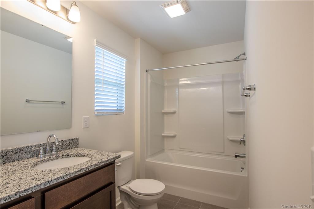 12532 Gotland Road, Unit 331 Midland, NC 28107 - Photo 19 of 26 a bathroom with a granite countertop sink toilet and shower