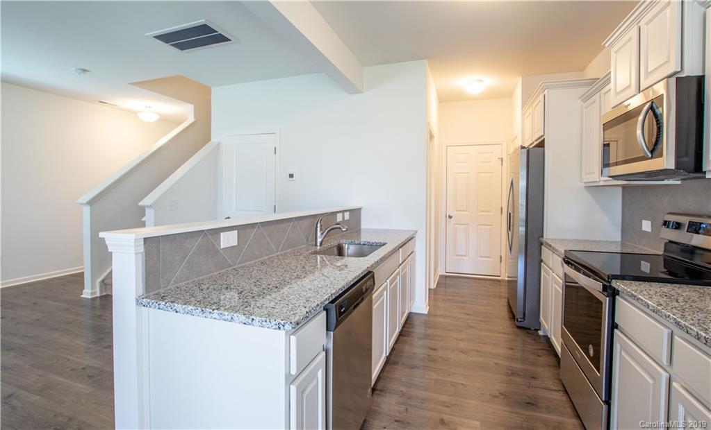 12532 Gotland Road, Unit 331 Midland, NC 28107 - Photo 10 of 26 a kitchen with stainless steel appliances granite countertop a kitchen island a stove a sink and a refrigerator