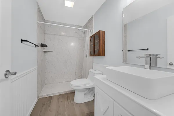 a bathroom with a sink a toilet and shower