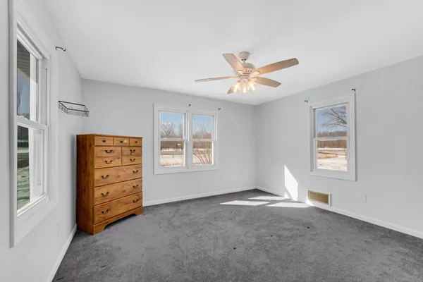 a view of room with cabinet and a ceiling fan