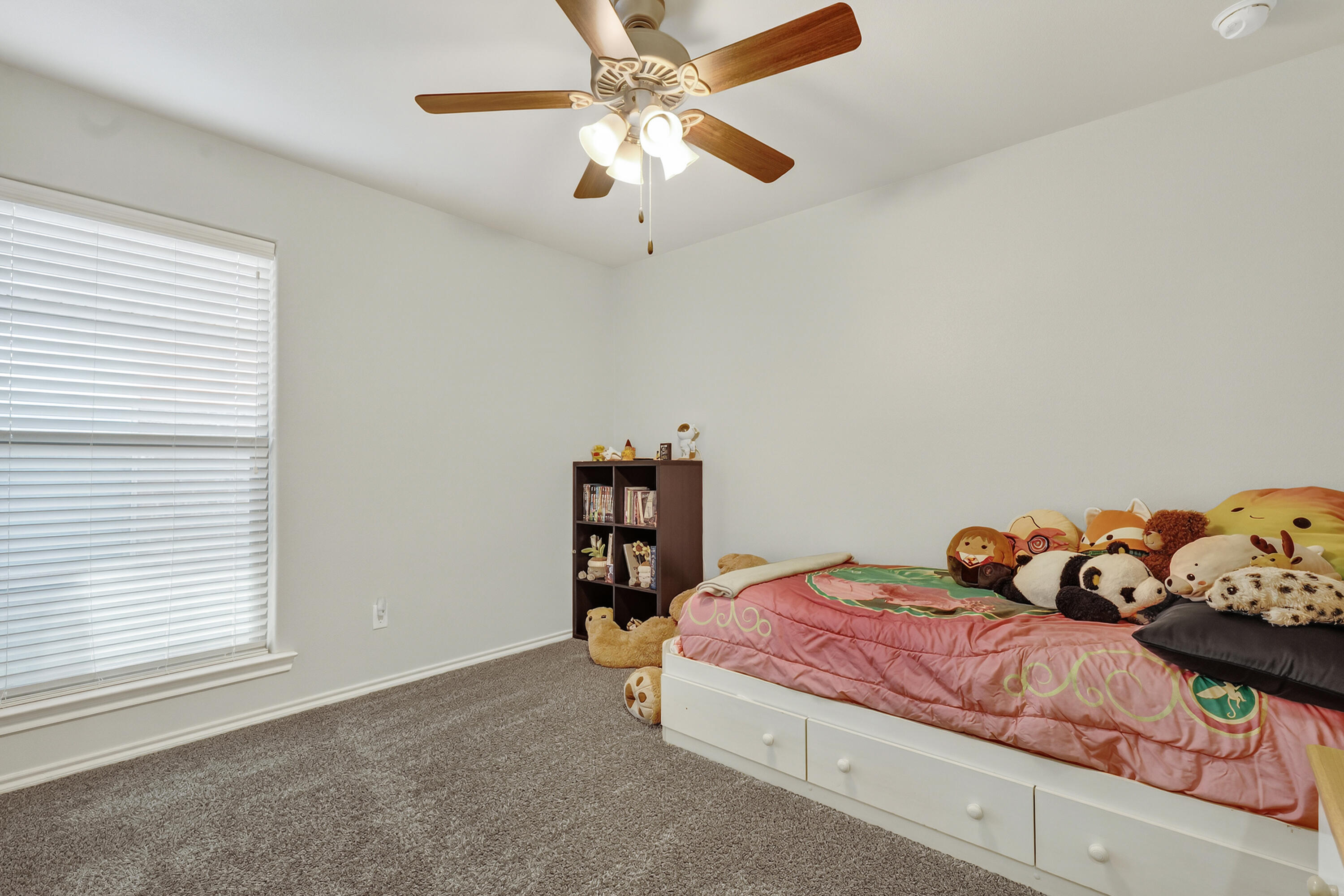7402 105th Street Lubbock, TX 79424 - Photo 17 of 22 a bedroom with a bed and a chandelier fan