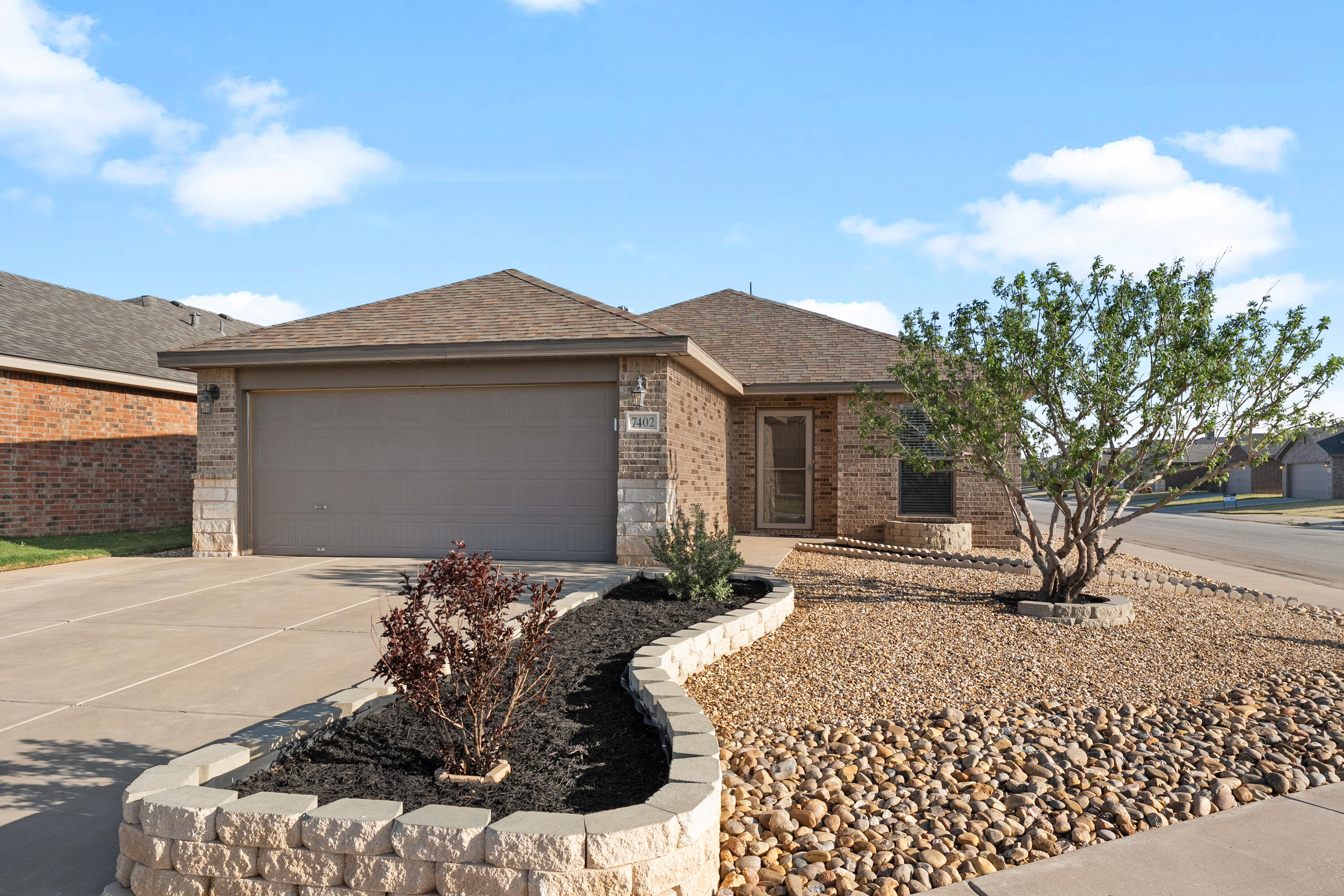 7402 105th Street Lubbock, TX 79424 - Photo 2 of 22 a front view of a house with a yard