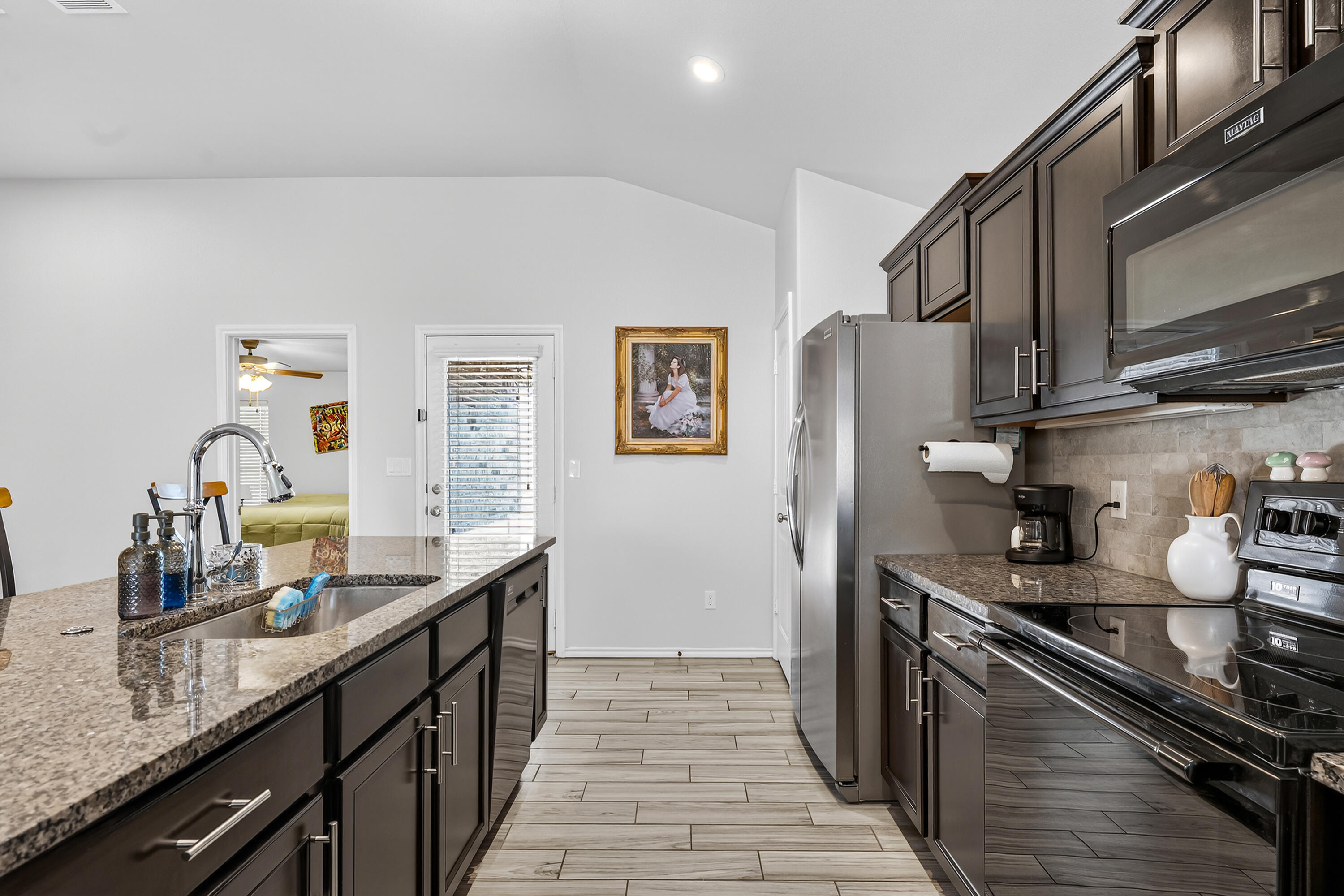 7402 105th Street Lubbock, TX 79424 - Photo 7 of 22 a kitchen with stainless steel appliances granite countertop a sink stove and refrigerator