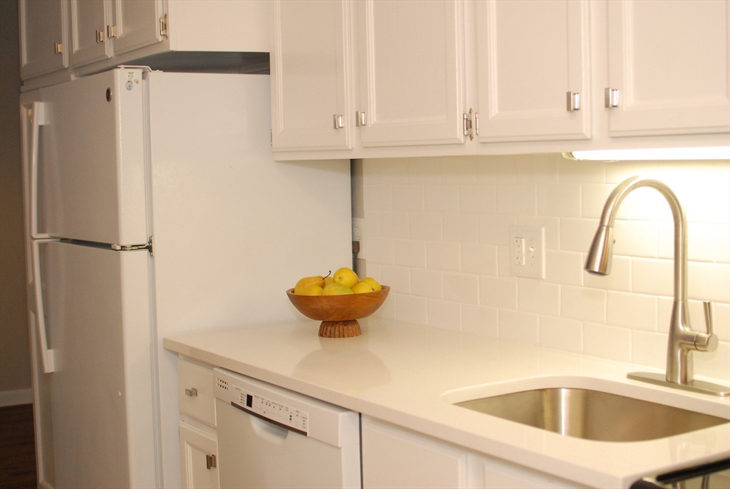 188 Swanson Road, Unit 330 Boxborough, MA 01719 - Photo 6 of 18 a kitchen with a sink and white cabinets