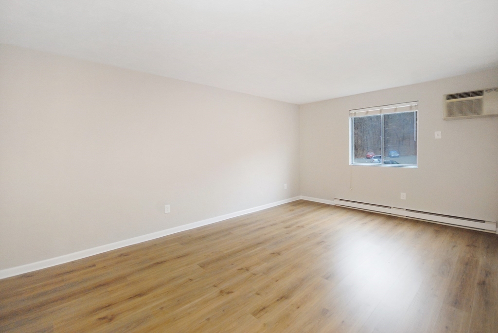 188 Swanson Road, Unit 330 Boxborough, MA 01719 - Photo 9 of 18 a view of an empty room with wooden floor and a window