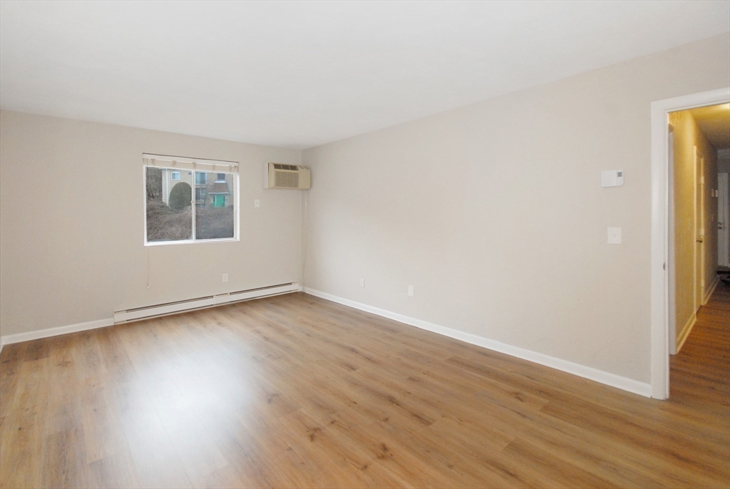 188 Swanson Road, Unit 330 Boxborough, MA 01719 - Photo 10 of 18 an empty room with wooden floor and window