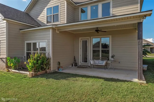 a view of a house with a big yard and large trees