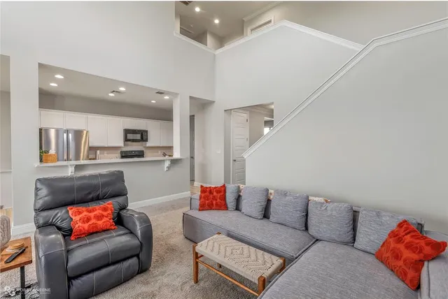 a living room with furniture and a view of kitchen
