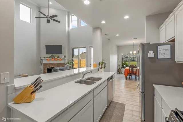 a kitchen that has a lot of cabinets a sink and a wooden floor