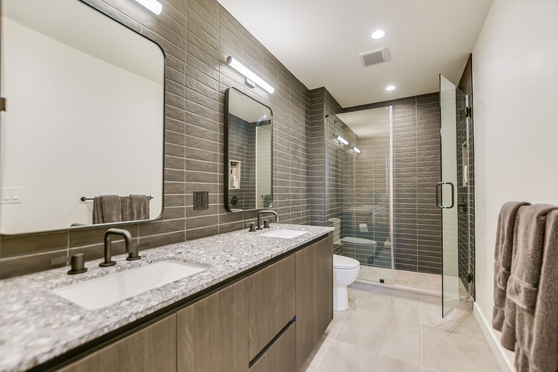 84 East Avenue, Unit 3909 Austin, TX 78701 - Photo 7 of 26 Full bath with a shower stall, double vanity, light tile patterned floors, recessed lighting, and tile walls