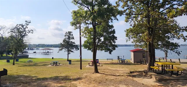 a view of a swimming pool with a bench and trees around