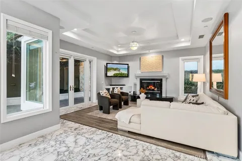 a living room with furniture and a large mirror with wooden floor