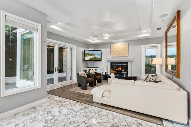 a living room with furniture and a large mirror with wooden floor