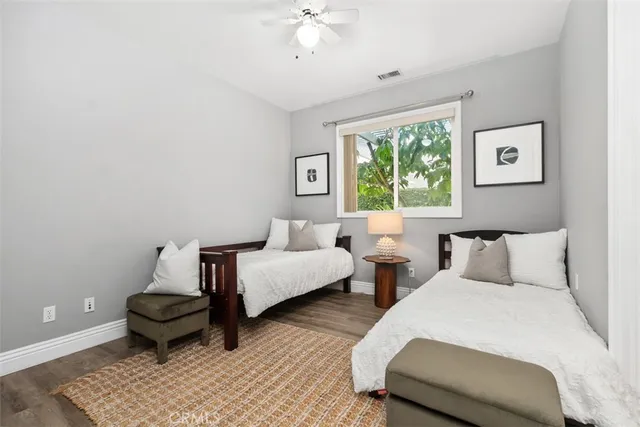 a spacious bedroom with a bed a chandelier and a dresser
