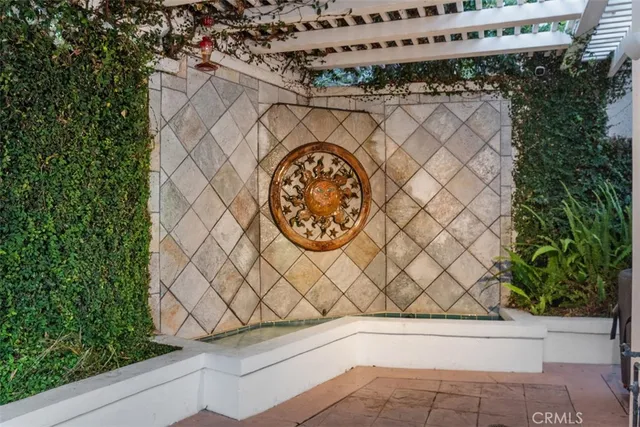 a front view of a house with a yard and fountain in middle of the road