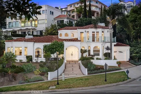 a view of a patio with couches and table and chairs with wooden floor and fence