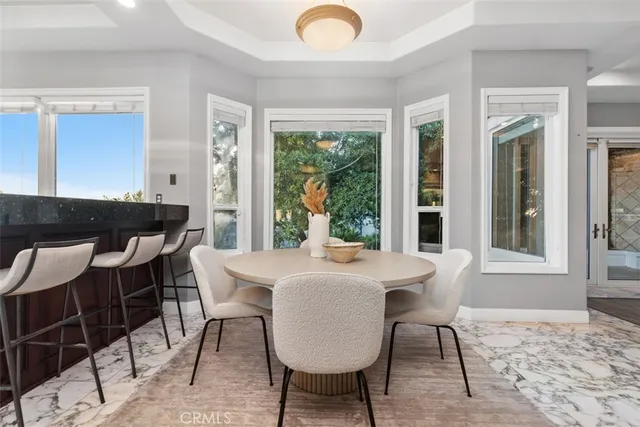 a living room with furniture a large window and potted plants