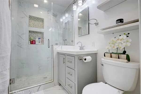 a bathroom with a sink a toilet and shower