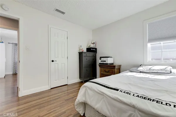 a bedroom with a bed and wooden floor