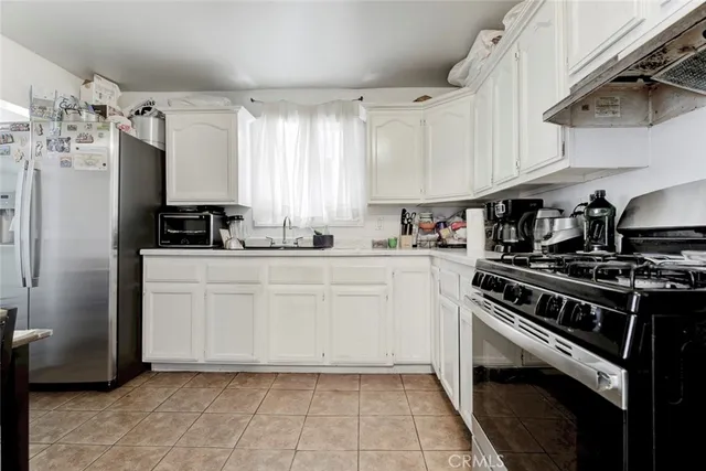 a kitchen with white cabinets and appliances