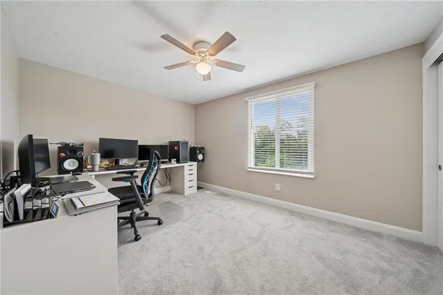 a view of a workspace with furniture and a window