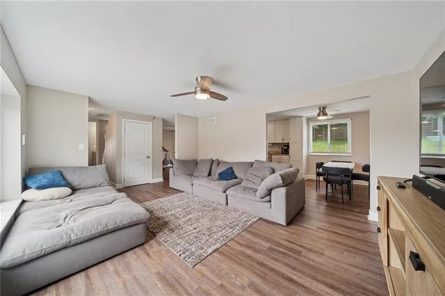 a living room with furniture and a wooden floor
