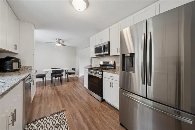 a kitchen with granite countertop a refrigerator stove and sink