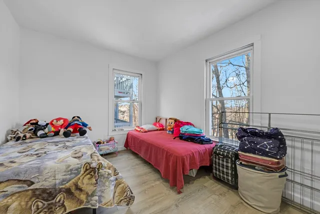 a bedroom with two beds and potted plant