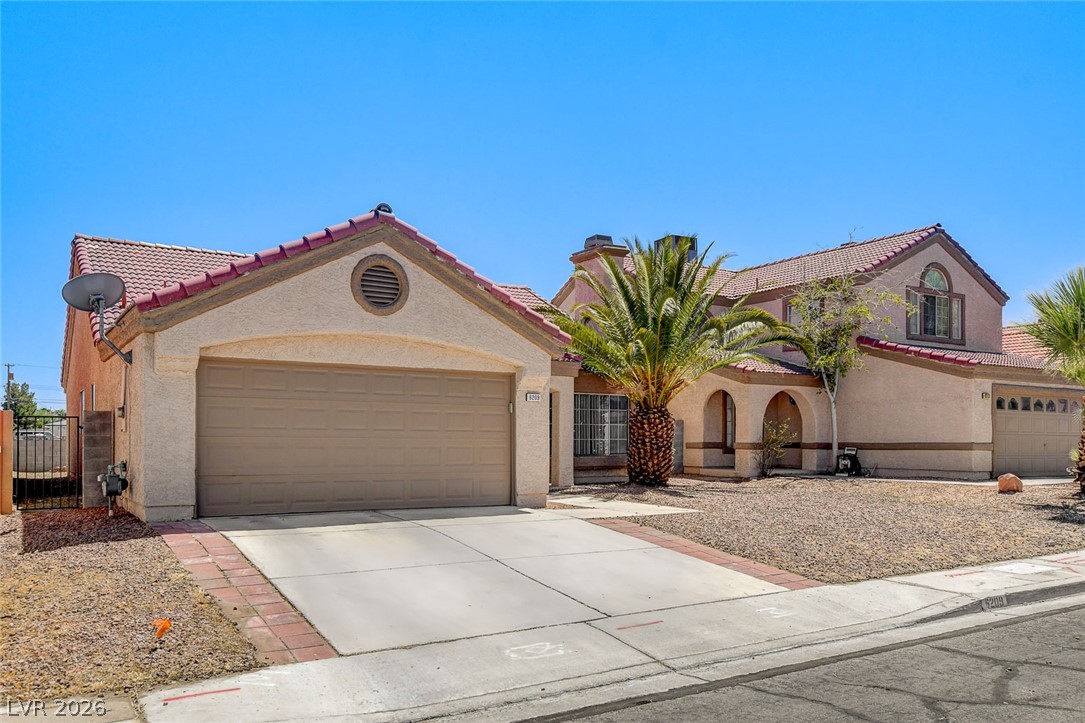 6209 Warm River Road Las Vegas, NV 89108 - Photo 2 of 39 A terracotta-tiled roof crowns this residence with archways and a lush palm accentuating its desert-adapted curb appeal.