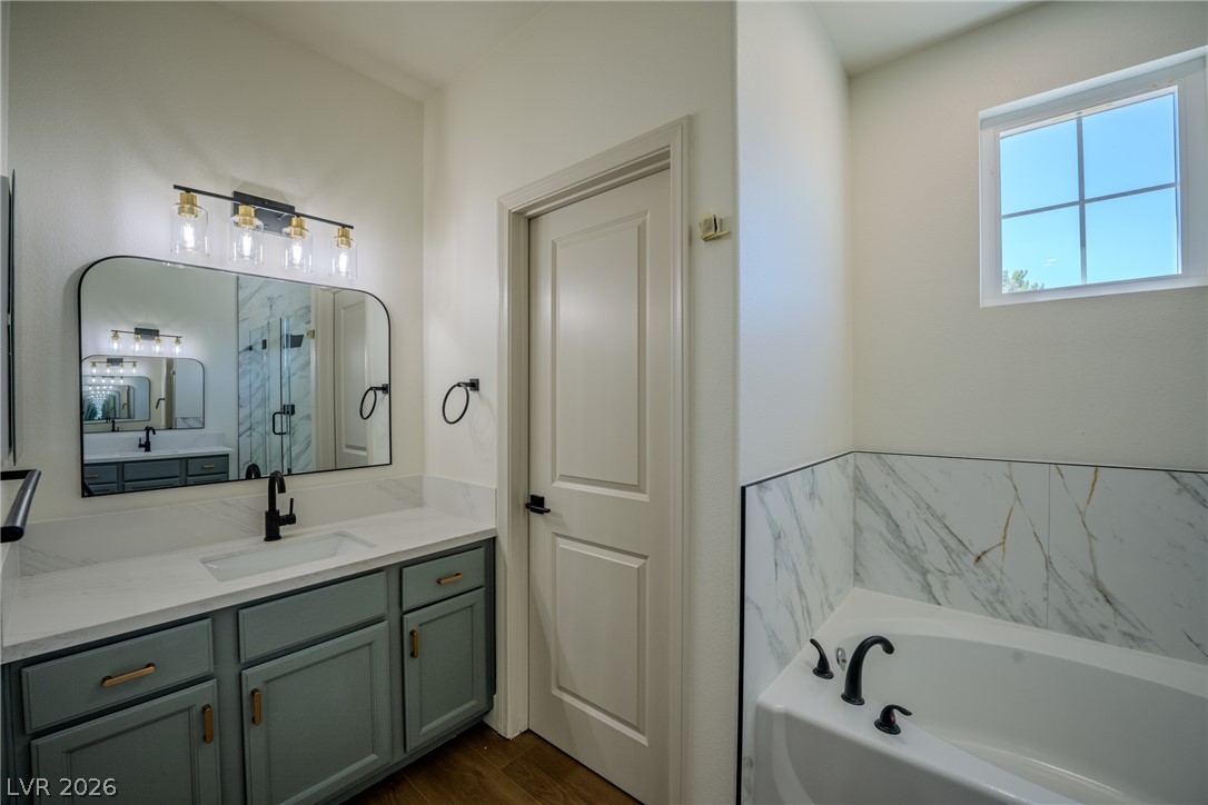 1832 Spring Summit Lane Las Vegas, NV 89134 - Photo 38 of 52 A well-appointed bathroom with a spacious vanity, a sleek mirror, and a generously sized bathtub beckons relaxation.