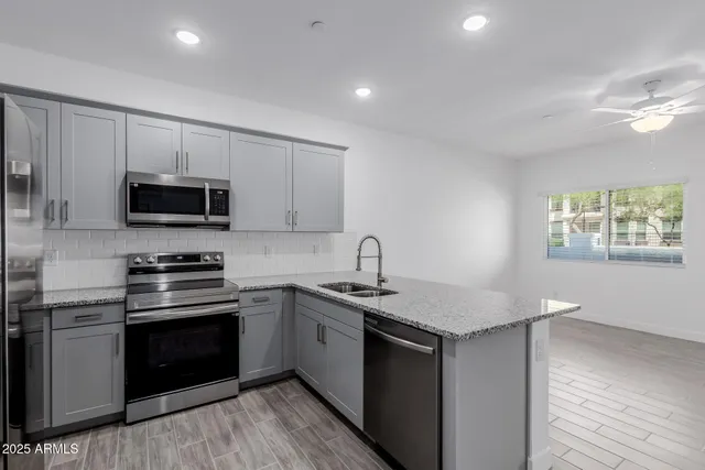 a kitchen with stainless steel appliances granite countertop a stove a sink and a microwave