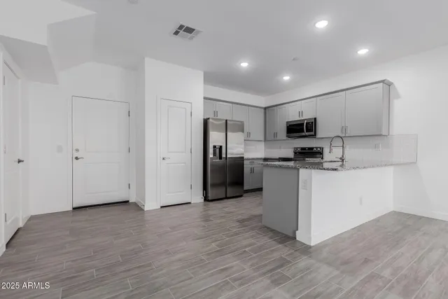 a kitchen with a refrigerator and a stove top oven