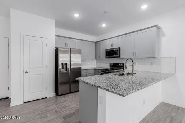 a kitchen with granite countertop a refrigerator and a sink