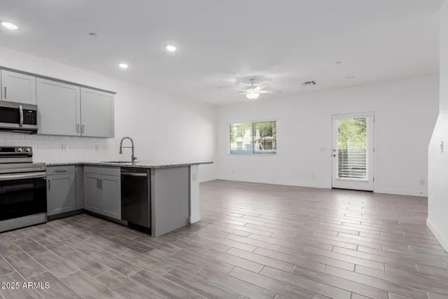 a kitchen with granite countertop a stove a sink and a microwave