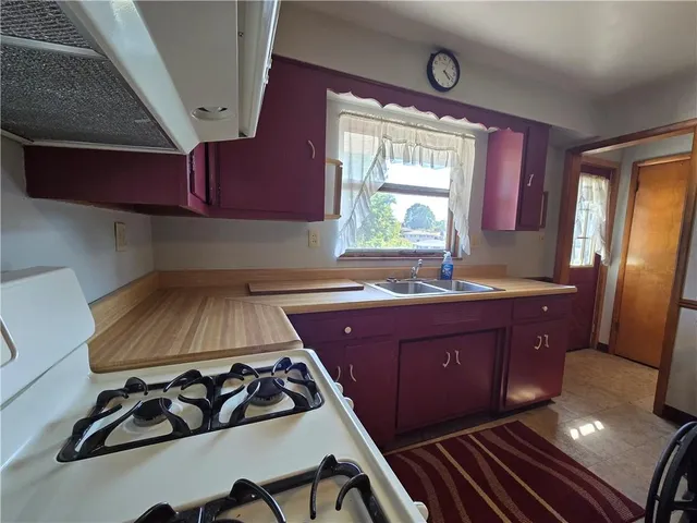 a kitchen with wooden cabinets a sink and a stove