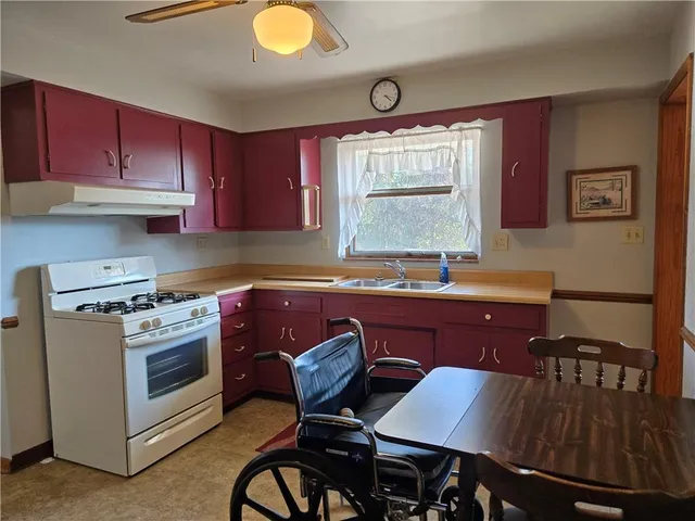 a kitchen with a stove a sink cabinets and dining table