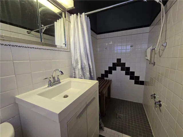 a bathroom with a sink and mirror with bathtub