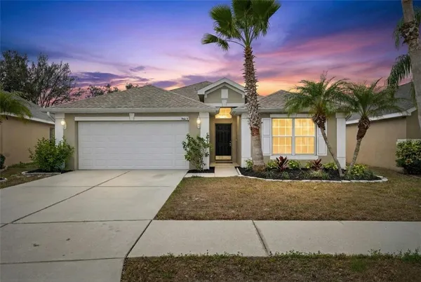 a front view of a house with a yard and potted plants