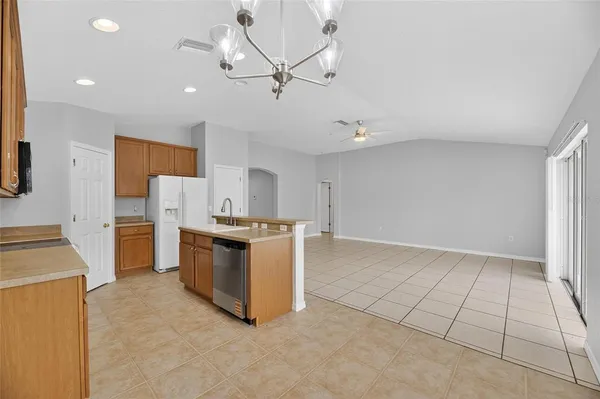 a kitchen with stainless steel appliances granite countertop a refrigerator a stove a sink and a oven