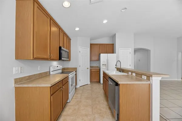 a view of an empty room and chandelier fan